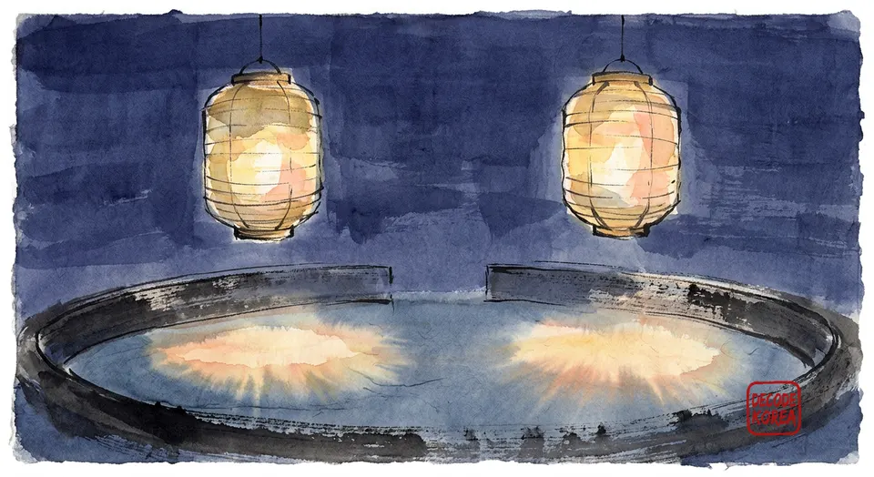 Two painted paper lanterns cast warm pools of light onto an empty abstract arena bowl.